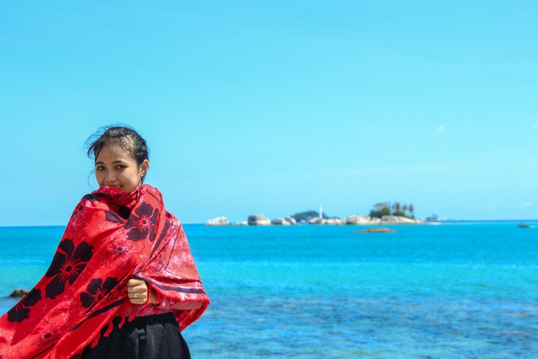 woman in red and black floral robe standing near shore