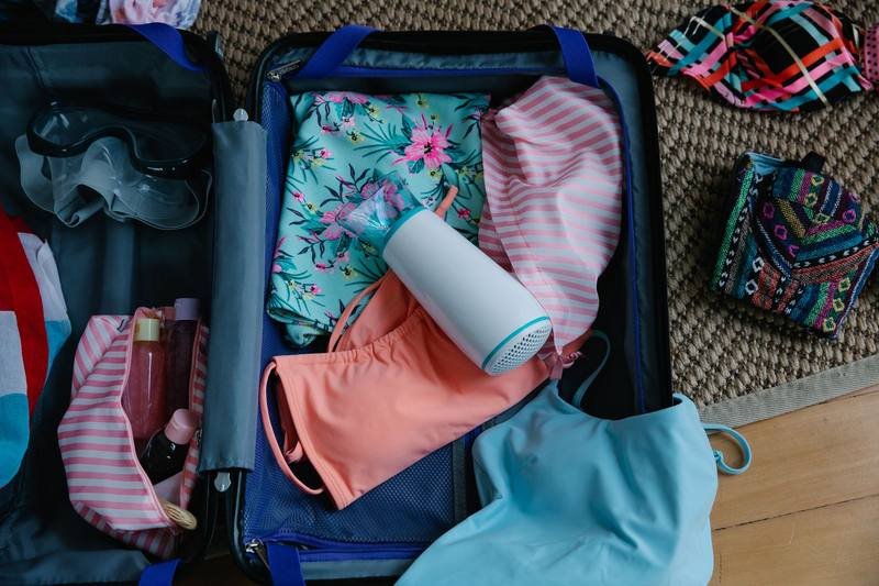 Packed suitcase with swimwear for a subscription box trial trip