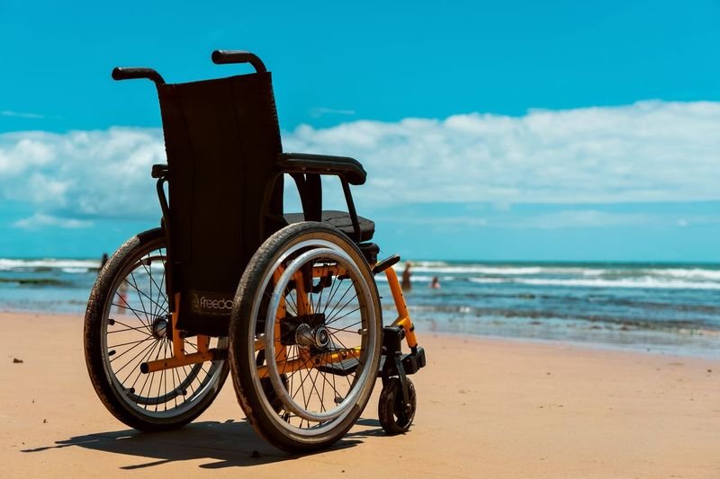 Wheelchair on a sunny beach representing accessible beach days