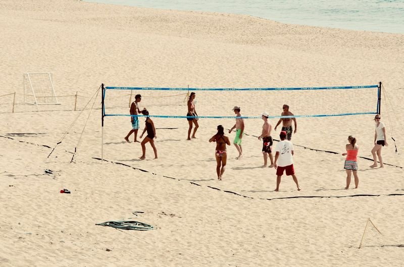 women playing a beach volleyball match on a sand court