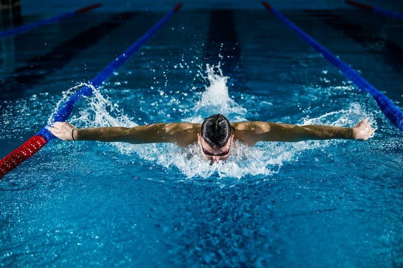 Competitive swimmer wearing a swim cap doing butterfly stroke