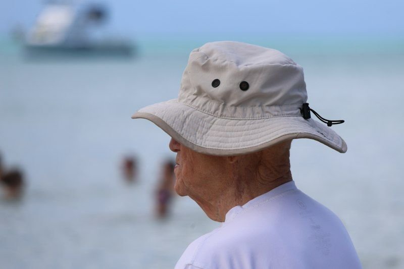 Man wearing a UPF bucket hat for sun protection by the ocean