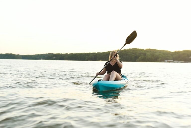 Woman wearing a bikini while kayaking on a calm lake