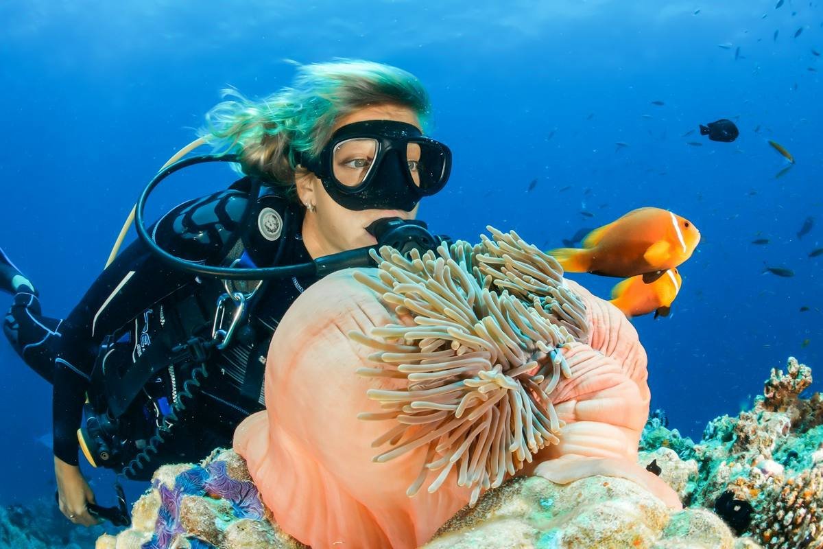 woman wearing scuba diving swimwear preparing to dive from a boat