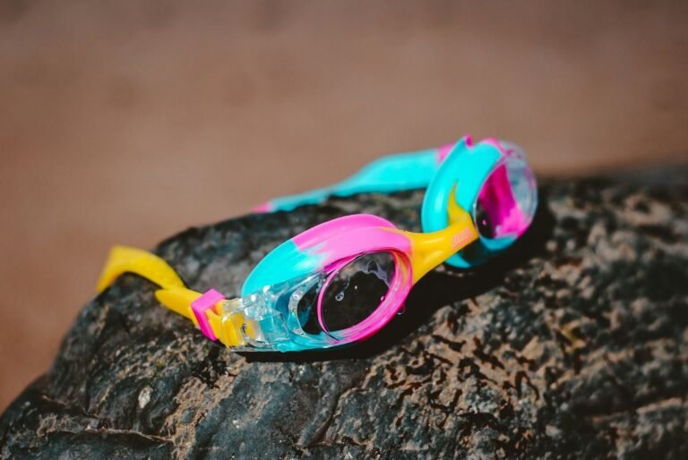 Swim goggles resting on a rock at the beach