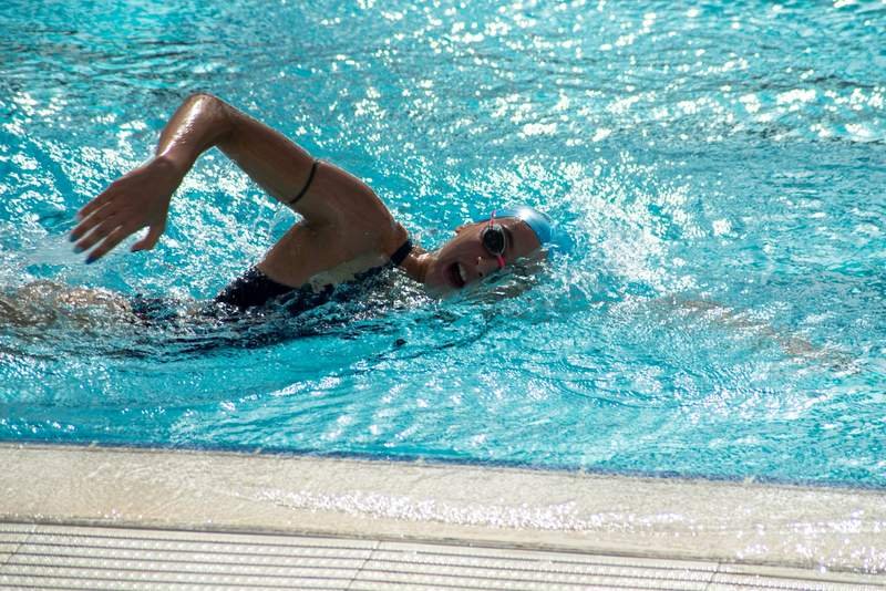 swimmer training static apnea breath-hold technique in a pool wearing a snug training swimsuit