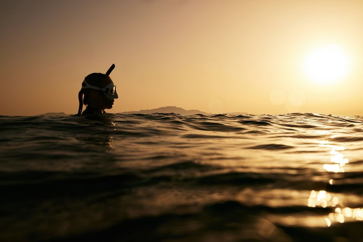 freediver swimming at sunset wearing secure freediving swimwear
