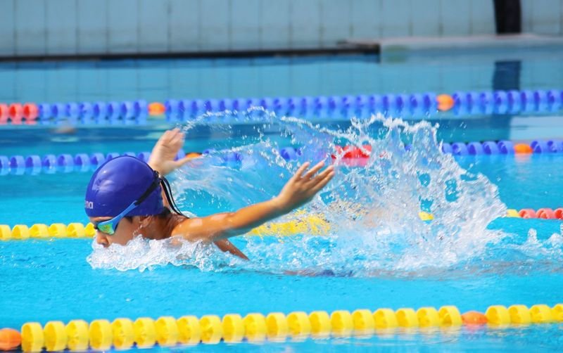 Swimmer adjusting a swim cap in the pool