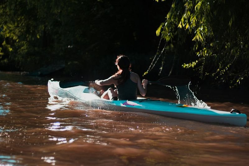 Woman in quick-dry kayaking swimwear paddling through a river