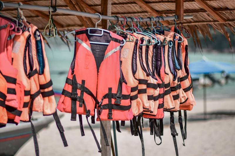 Rack of orange life vests at a lake dock for water sports