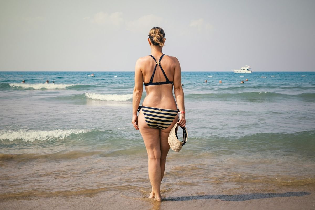 Woman feeling confident in mastectomy swimwear on the beach