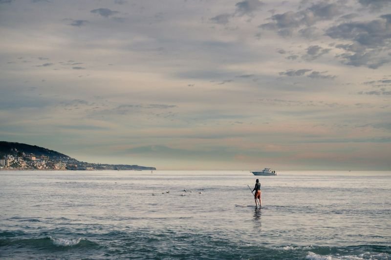 Paddleboarder in swimwear balancing on a calm ocean