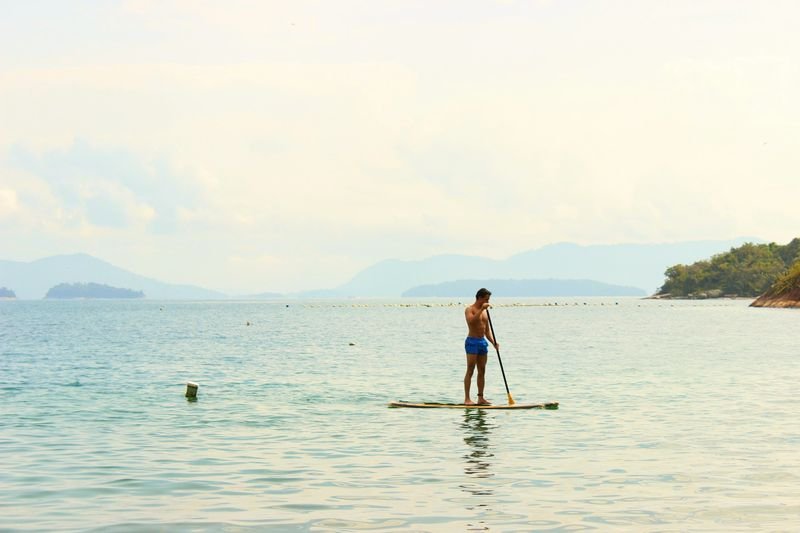 Person standing on a paddleboard wearing a secure-fit swimsuit