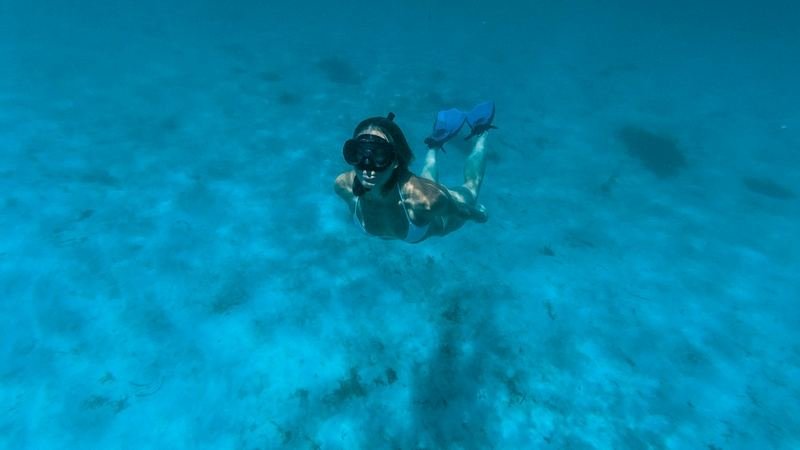 diver wearing fins and swimwear in clear water after a dive