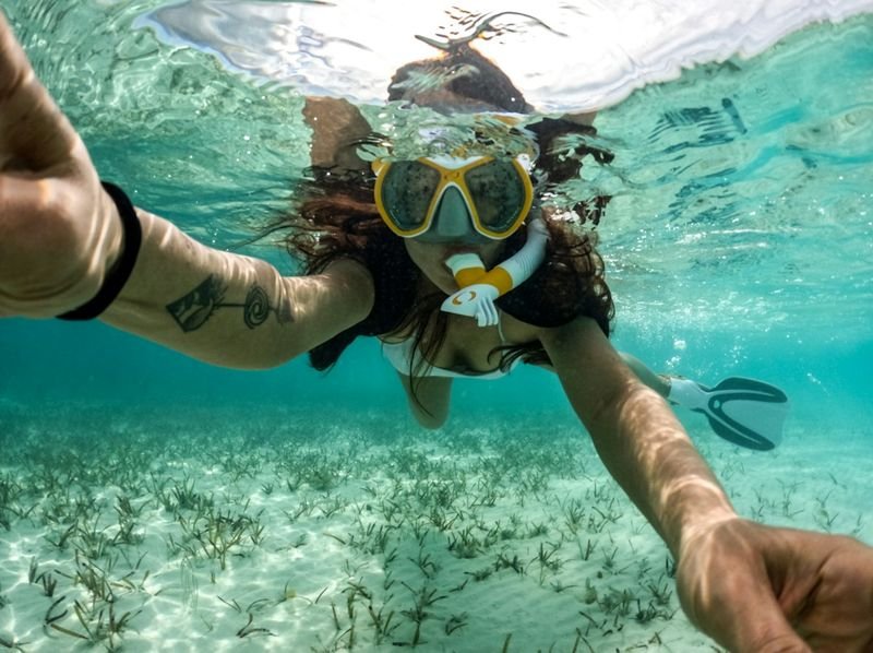 woman snorkeling in well-fitted swimwear in clear ocean water