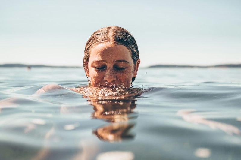 Swimmer wearing a cap swimming in open water