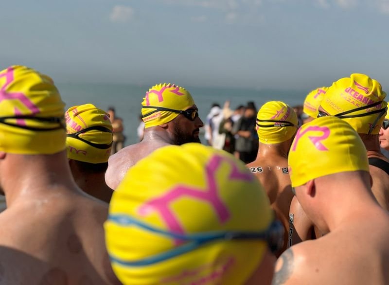 Group of swimmers wearing bathing caps at a competition pool
