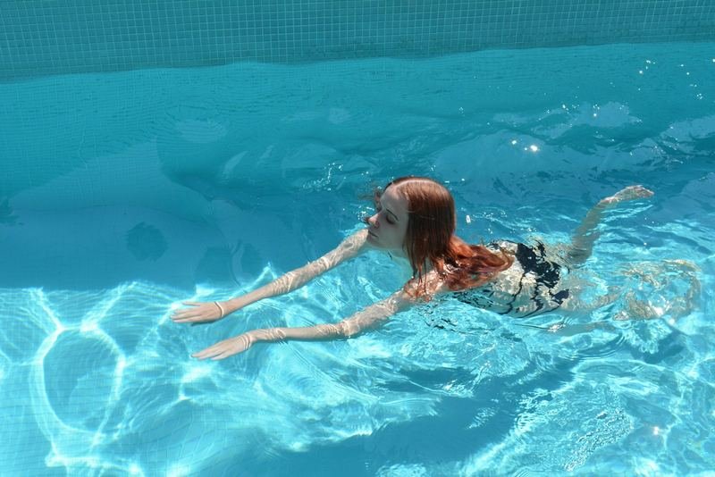 Woman swimming calmly in a pool for menopause symptom relief