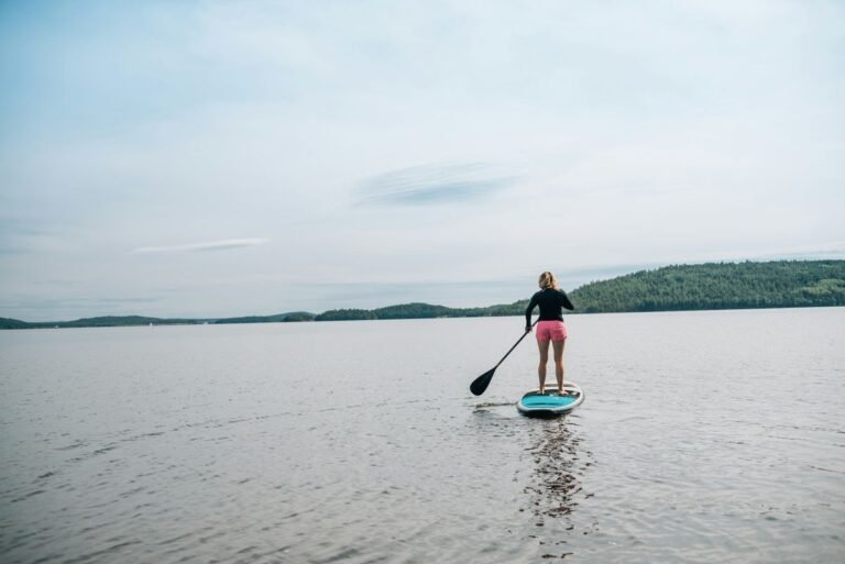 Woman wearing secure athletic swimwear while stand up paddleboarding