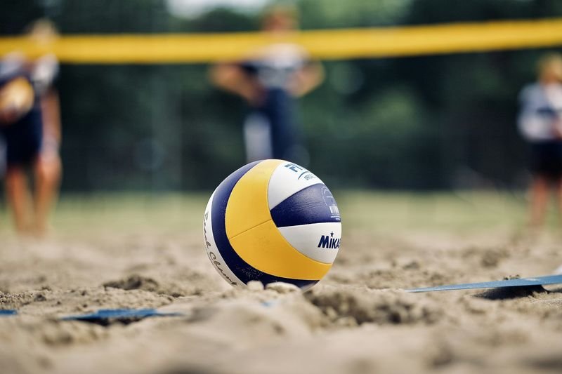 close up of a volleyball resting in beach sand