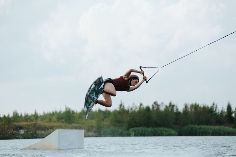 Wakeboarder launching off a kicker ramp in secure wakeboarding swimwear