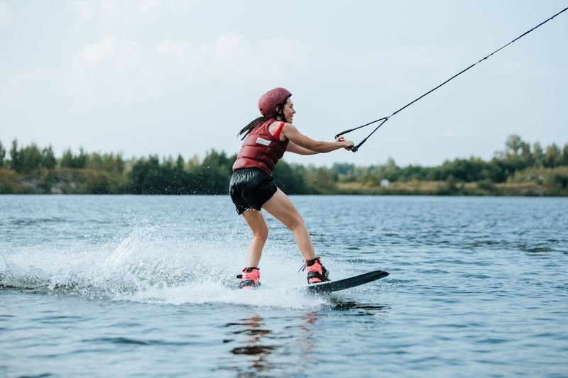Wakeboarder in red athletic wakeboarding swimwear with high-waisted bottoms