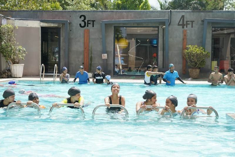 Water aerobics swimwear class stretching poolside