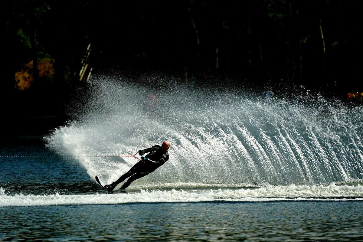 Water skier carving a hard slalom turn in secure water skiing swimwear