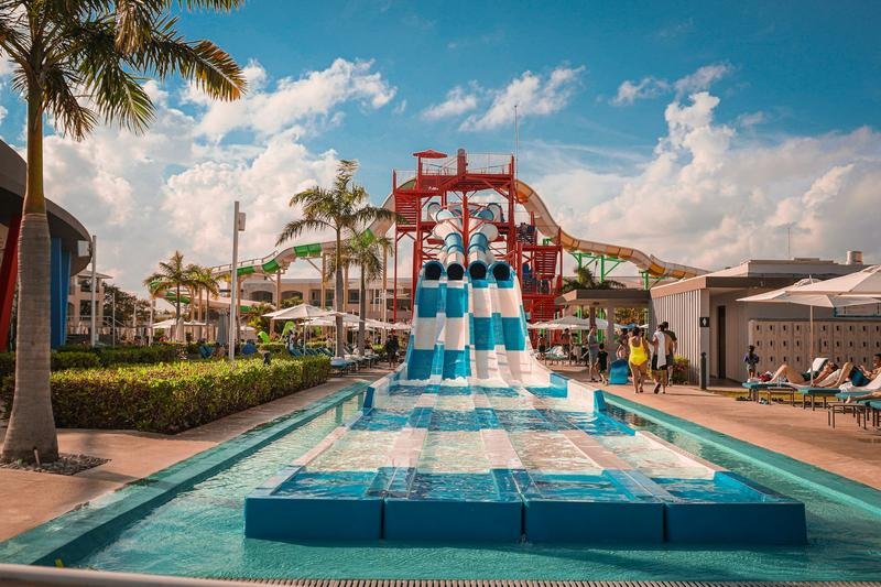 water park resort with blue and white body slides and palm trees