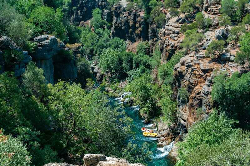 rafters in swimwear floating down a turquoise canyon river