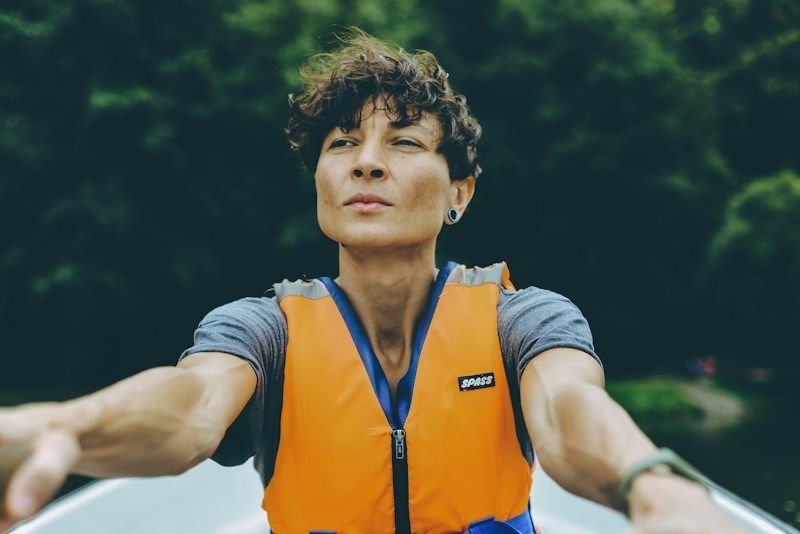 rafter wearing an orange life vest over quick-dry swimwear